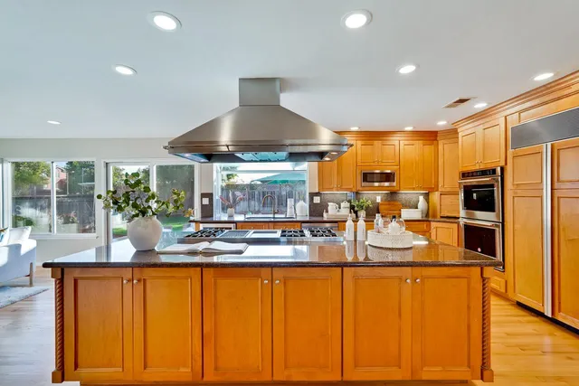 a kitchen with stainless steel appliances granite countertop a refrigerator and a sink