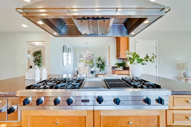 a kitchen sink with granite countertop a view of living room