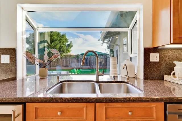 a living room with furniture kitchen and a potted plant