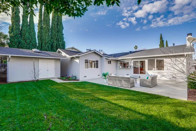 a view of a house with a yard and sitting area