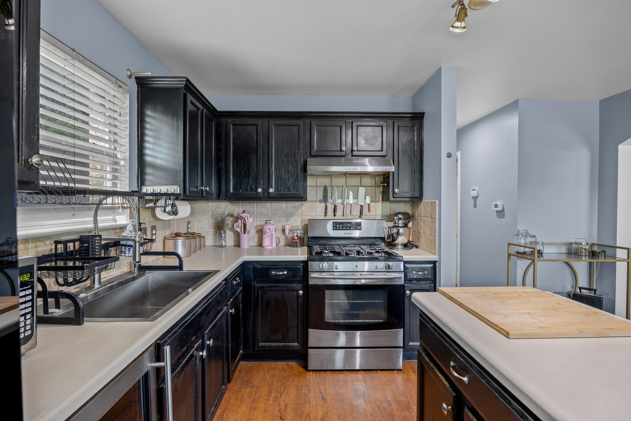 641 Fort Thomas Place Round Rock, TX 78664 - Photo 8 of 28 Kitchen featuring stainless steel appliances, light countertops, beverage cooler, large sink, center island and light wood-look laminate flooring