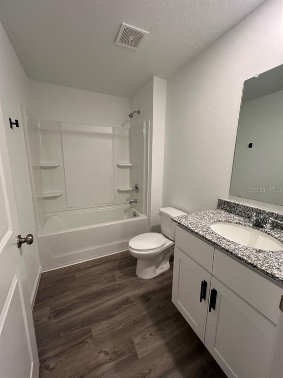 9131 Swiss Road Spring Hill, FL 34606 - Photo 12 of 16 a bathroom with a granite countertop sink toilet a mirror and shower