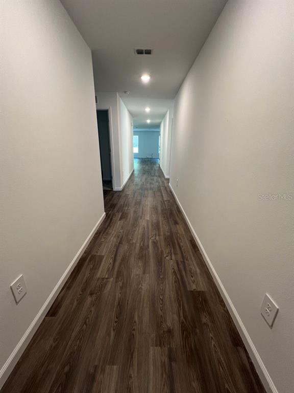 9131 Swiss Road Spring Hill, FL 34606 - Photo 3 of 16 a view of a hallway with wooden floor