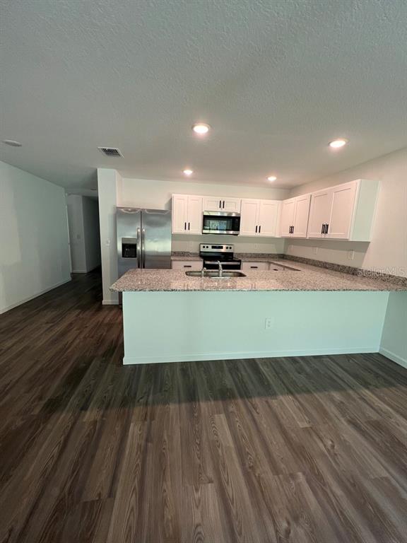 9131 Swiss Road Spring Hill, FL 34606 - Photo 4 of 16 a large kitchen with lots of counter space and wooden floor