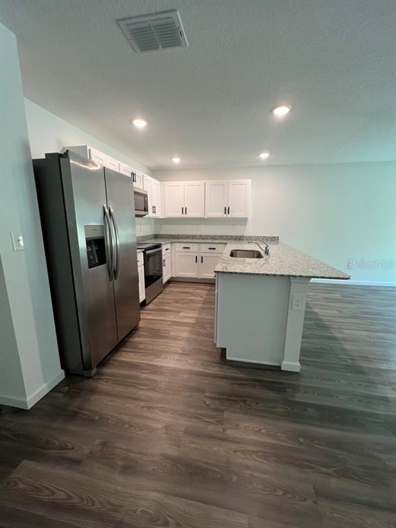 9131 Swiss Road Spring Hill, FL 34606 - Photo 5 of 16 a kitchen with stainless steel appliances granite countertop a sink stove and refrigerator