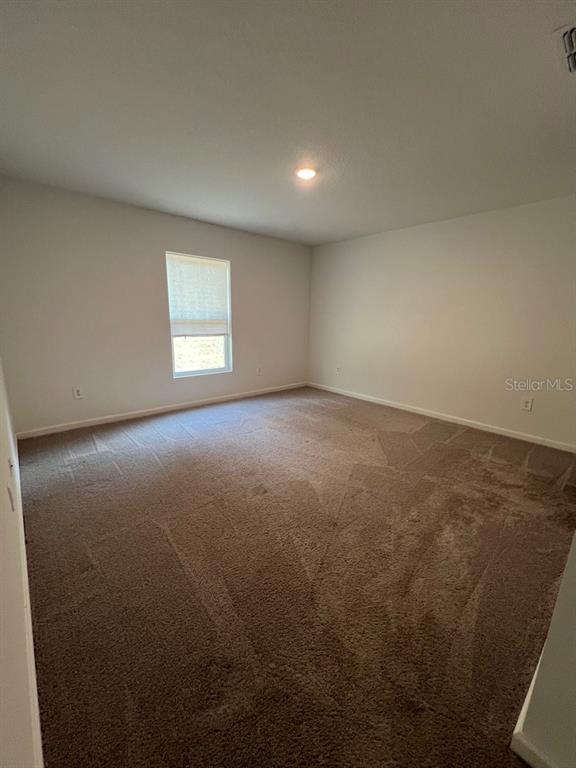 9131 Swiss Road Spring Hill, FL 34606 - Photo 8 of 16 an empty room with a window and a kitchen