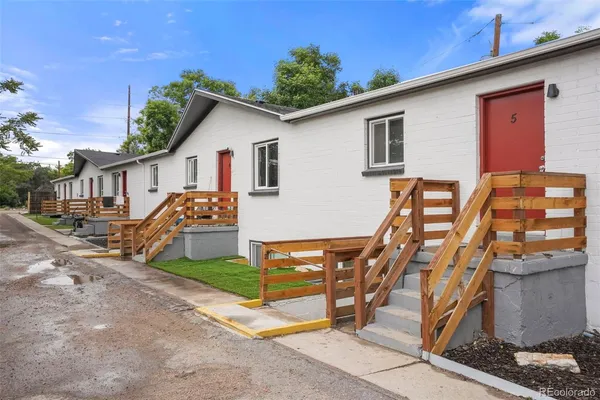 a view of a house with wooden deck and furniture