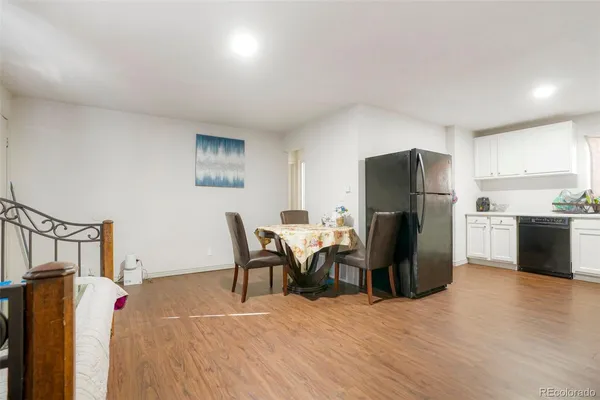 a view of a dining room with furniture and a refrigerator