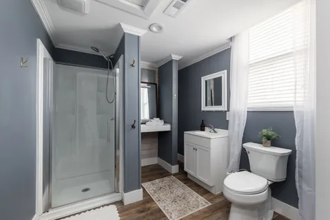 a bathroom with a granite countertop toilet a sink and a mirror