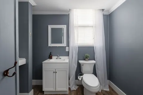 a bathroom with a toilet a sink and mirror