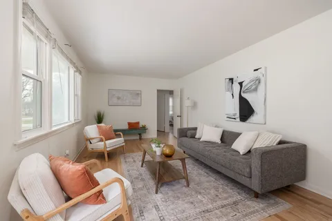 a living room with furniture wooden floor and a large window