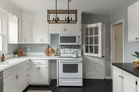 a kitchen with stainless steel appliances white cabinets and a stove a oven with white countertops