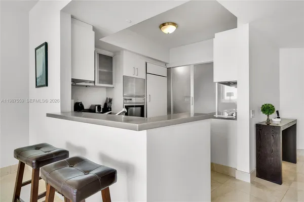 a kitchen with granite countertop white cabinets and white appliances