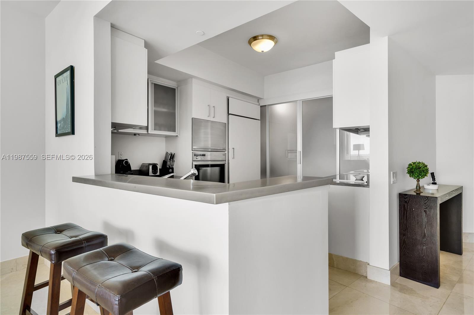 450 Alton Road, Unit 2005 Miami Beach, FL 33139 - Photo 6 of 19 a kitchen with stainless steel appliances granite countertop a refrigerator and a stove