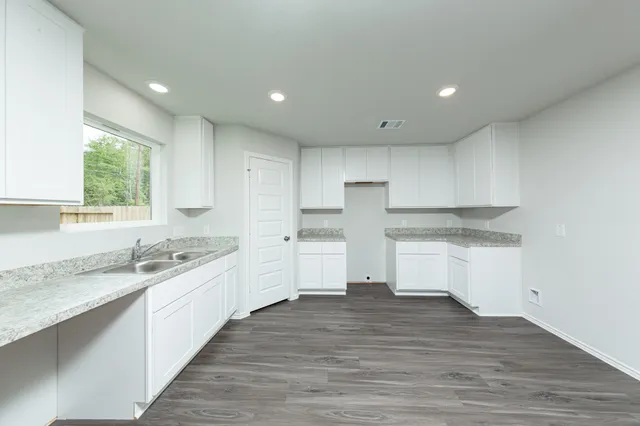 a kitchen with stainless steel appliances granite countertop a sink and a stove top oven
