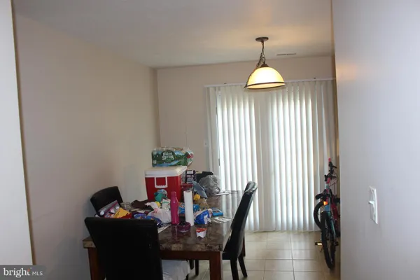 a dining room with furniture a chandelier and a window