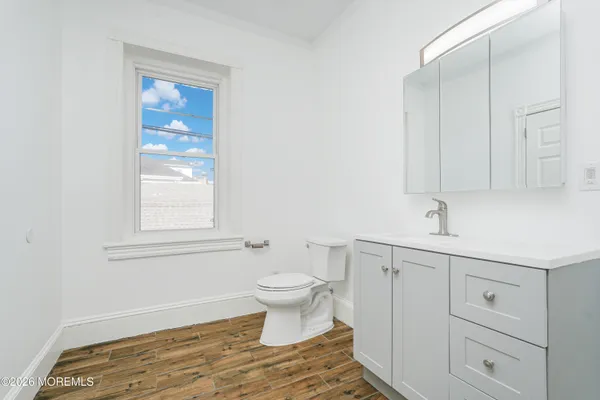 a bathroom with a sink a toilet and a window