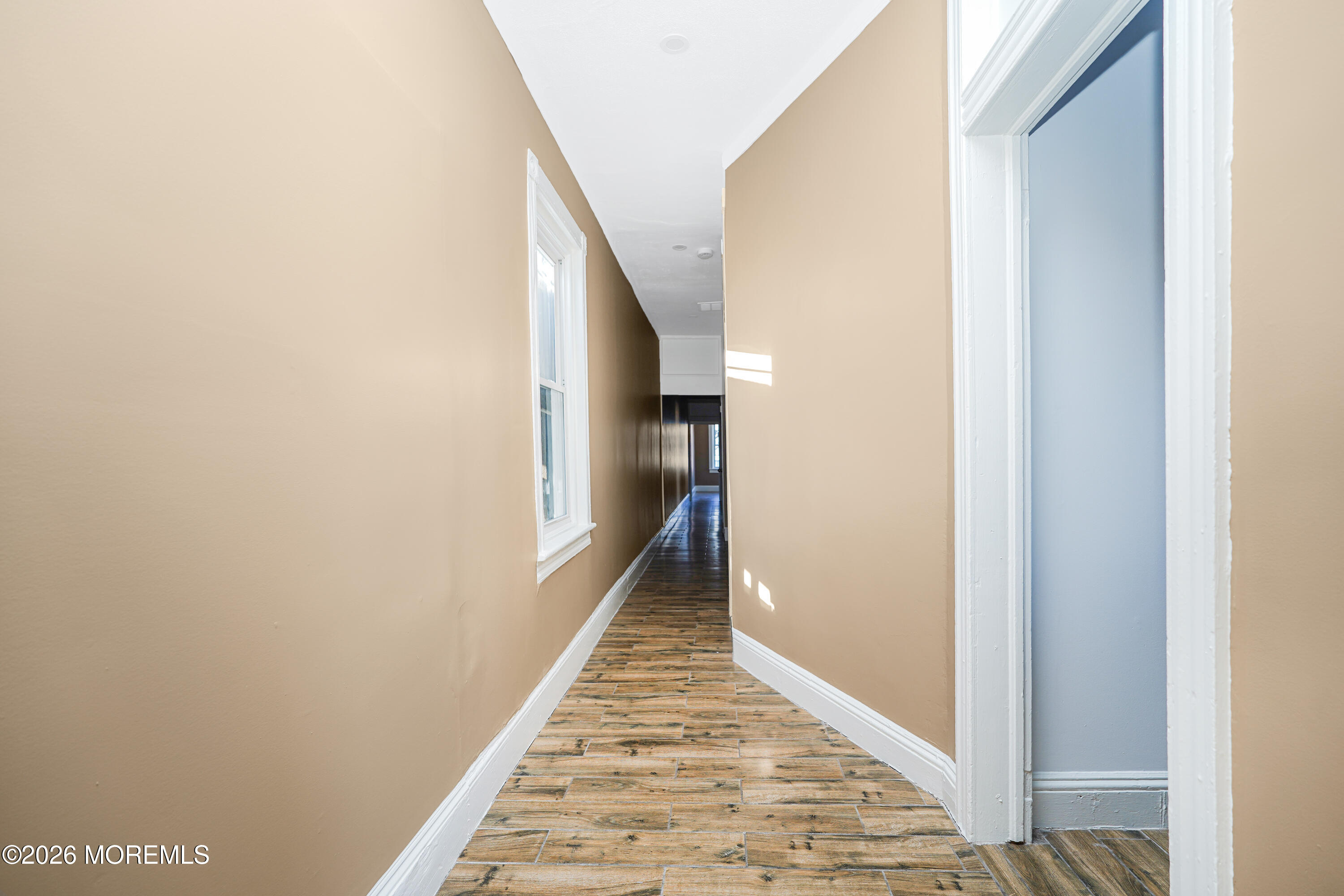 Undisclosed Address Matawan, NJ 07747 - Photo 7 of 18 a view of a hallway with wooden floor and staircase