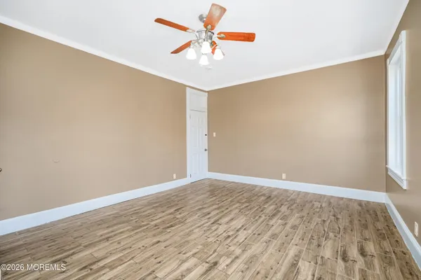 an empty room with wooden floor and a window