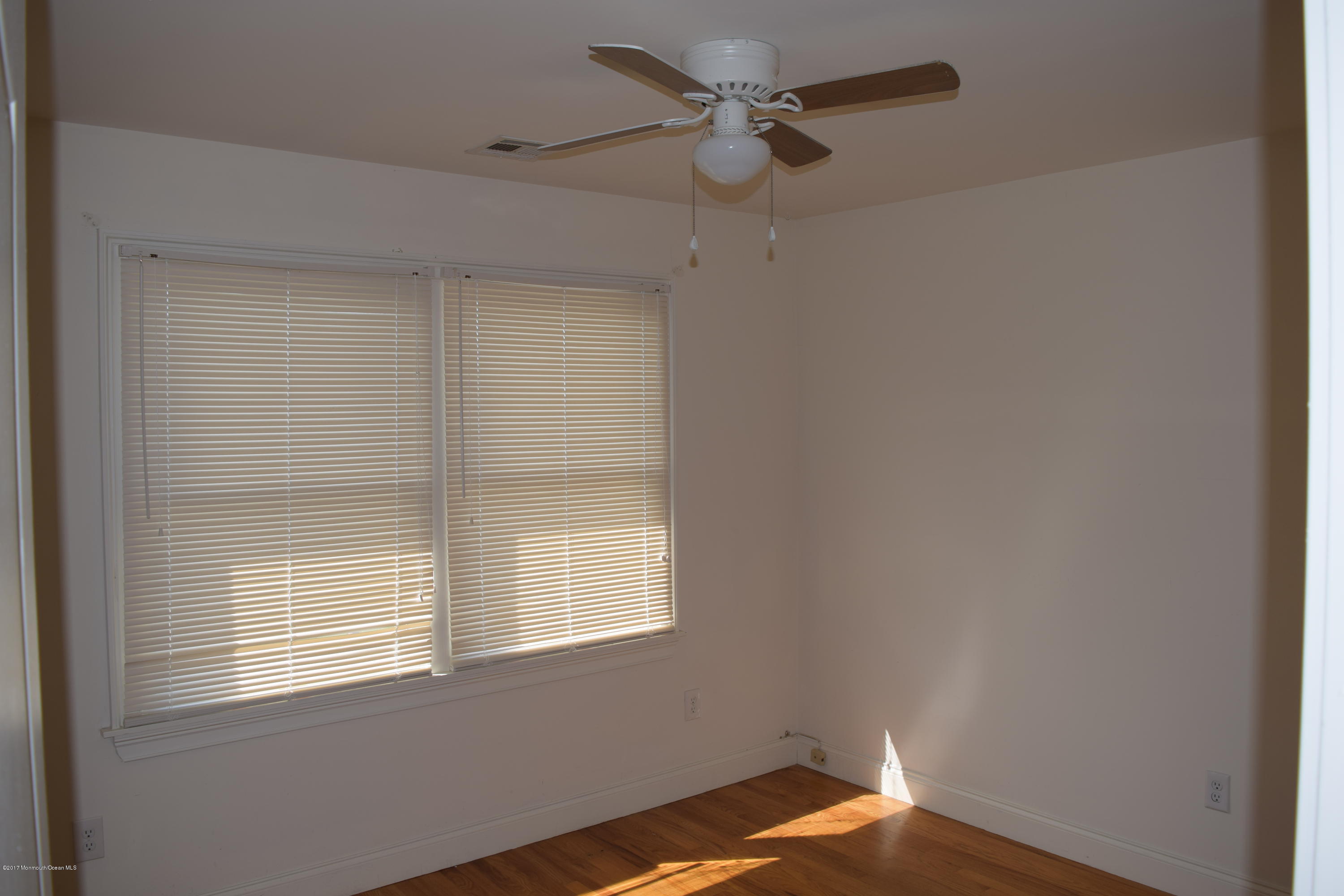 612 Front Street, Unit 7 Union Beach, NJ 07735 - Photo 11 of 15 a view of empty room with wooden floor and fan
