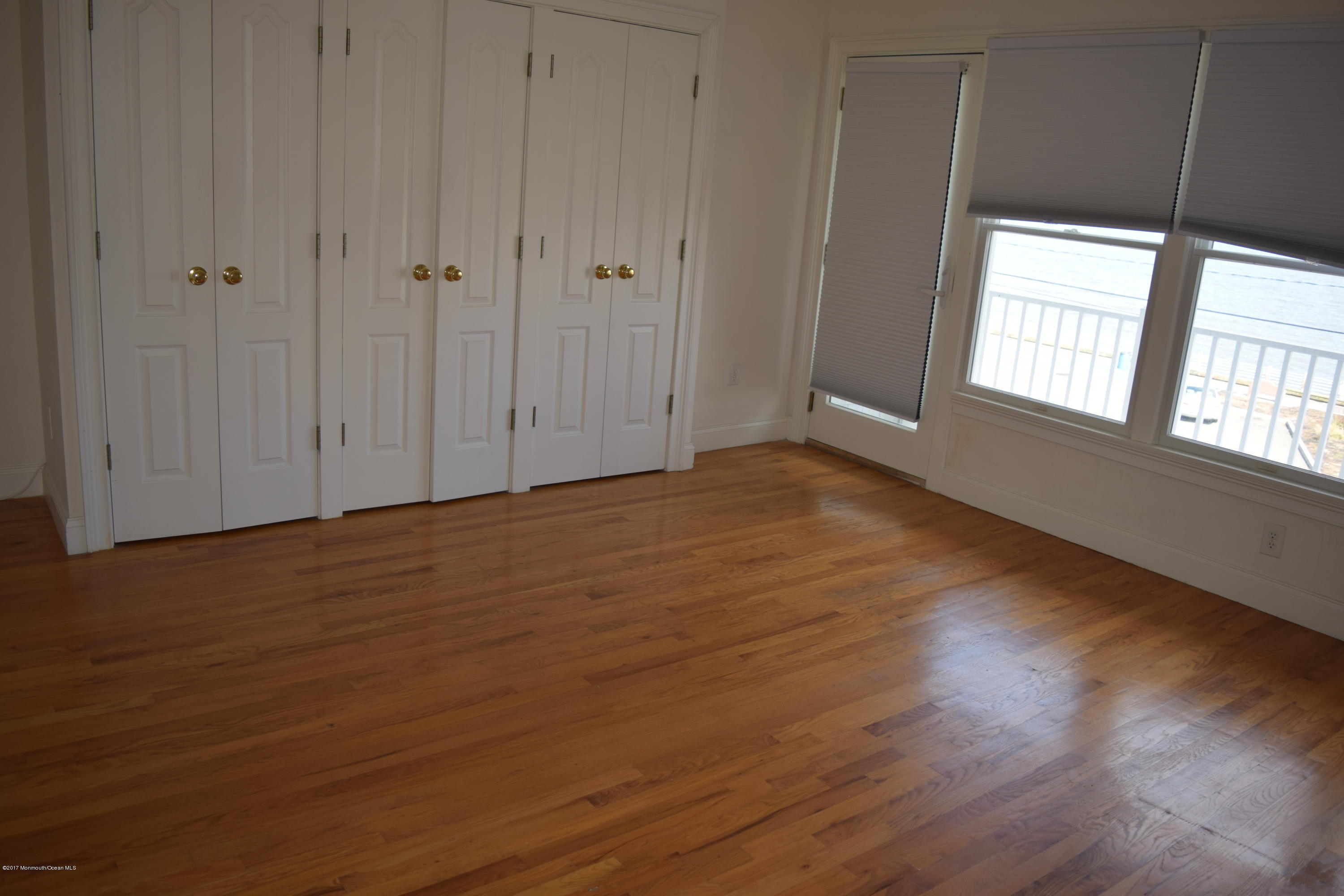 612 Front Street, Unit 7 Union Beach, NJ 07735 - Photo 12 of 15 a view of an empty room with wooden floor and a window