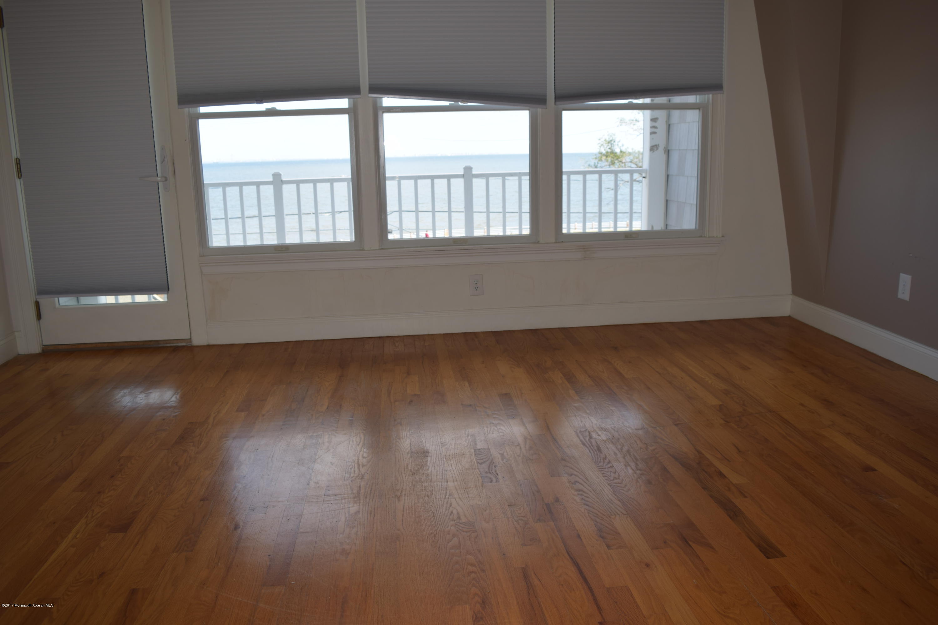 612 Front Street, Unit 7 Union Beach, NJ 07735 - Photo 13 of 15 an empty room with wooden floor and windows