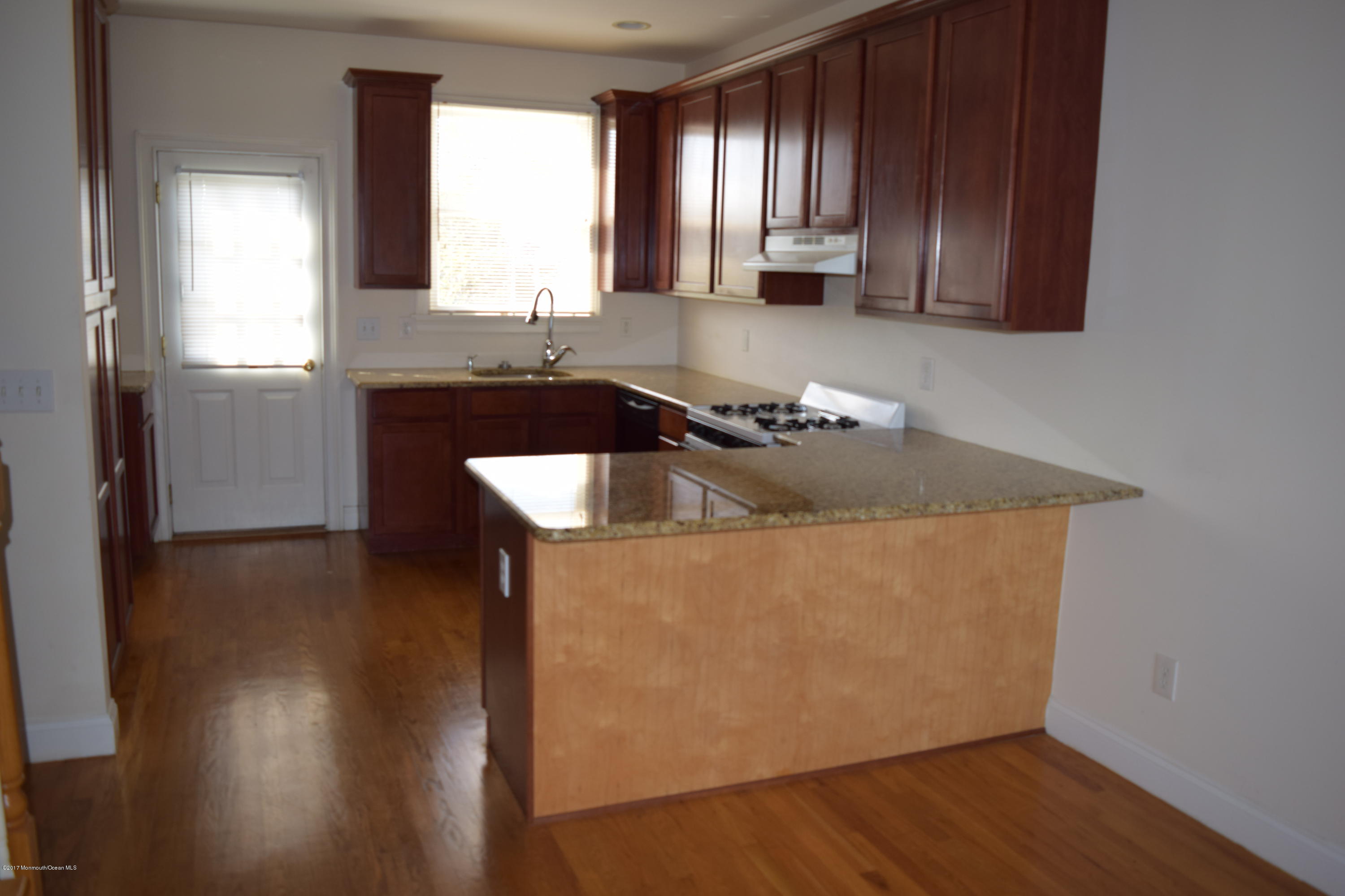 612 Front Street, Unit 7 Union Beach, NJ 07735 - Photo 4 of 15 a kitchen with stainless steel appliances granite countertop a sink a microwave counter space and wooden floor