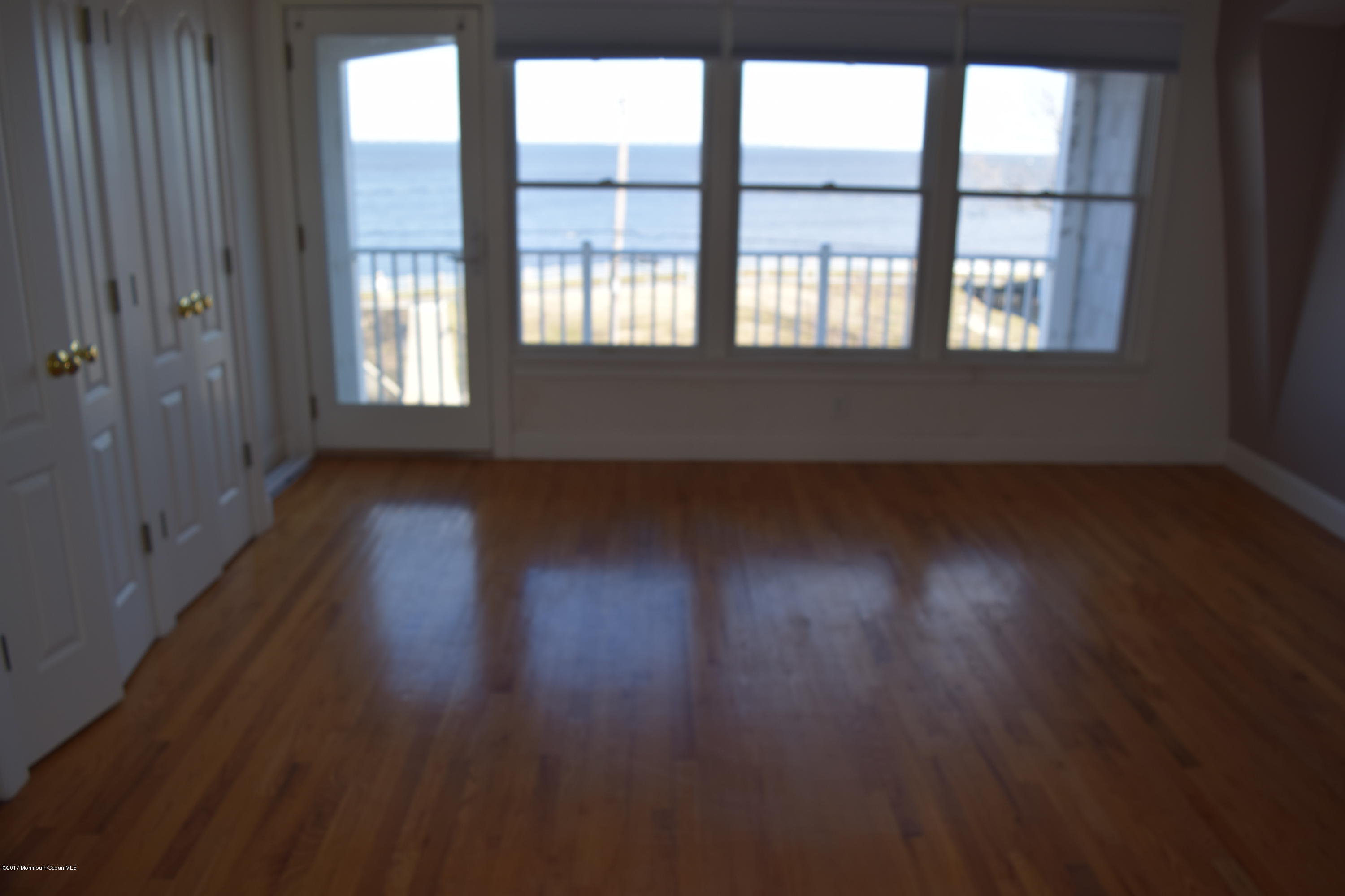 612 Front Street, Unit 7 Union Beach, NJ 07735 - Photo 6 of 15 an empty room with wooden floor and windows