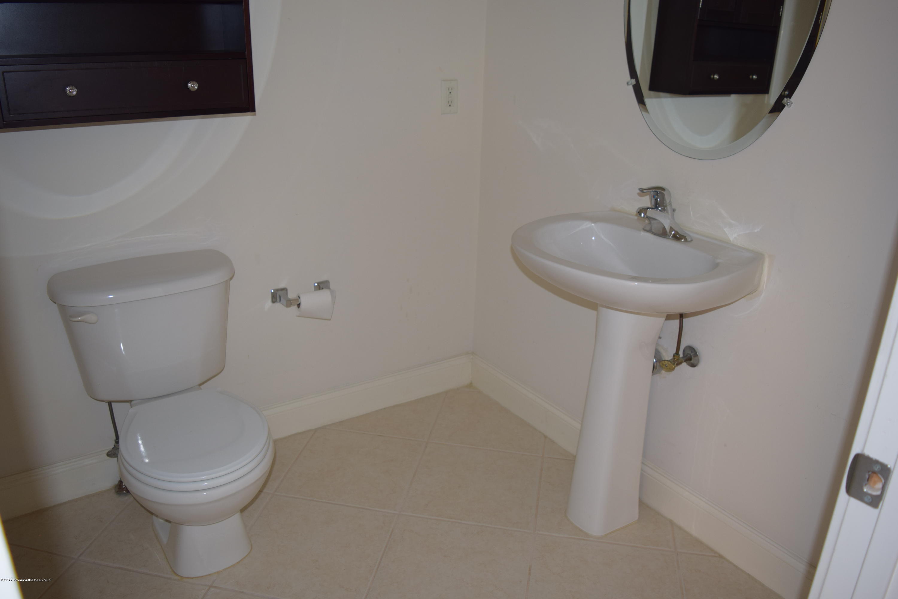 612 Front Street, Unit 7 Union Beach, NJ 07735 - Photo 7 of 15 a bathroom with a toilet sink and mirror