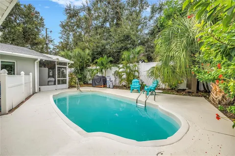 a view of a house with a backyard and a tree