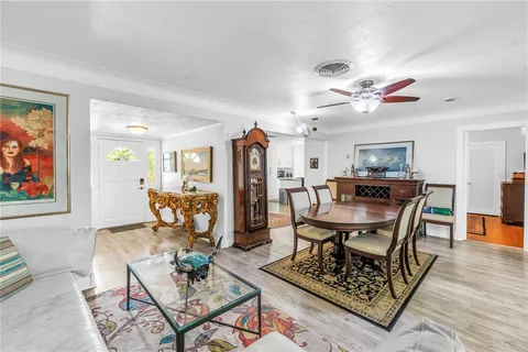 a view of a dining room with furniture a rug and wooden floor