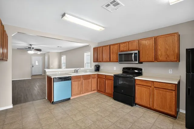 a kitchen with granite countertop a stove top oven sink and cabinets