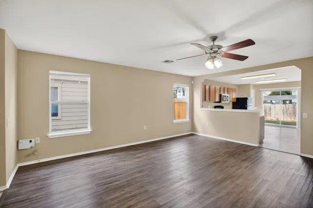 a view of a kitchen with wooden floor and a ceiling fan