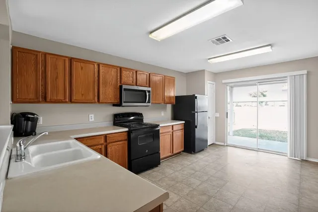 a kitchen with stainless steel appliances granite countertop a refrigerator stove top oven a sink and dishwasher