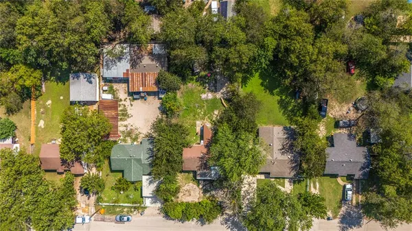 an aerial view of residential houses with outdoor space and trees