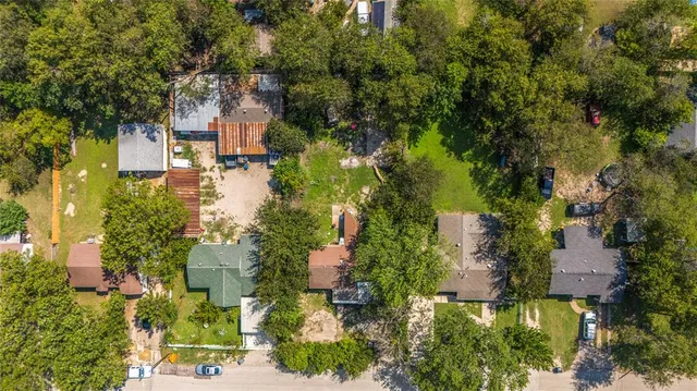 an aerial view of residential houses with outdoor space and trees