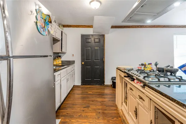 a kitchen with stainless steel appliances granite countertop a refrigerator and a stove