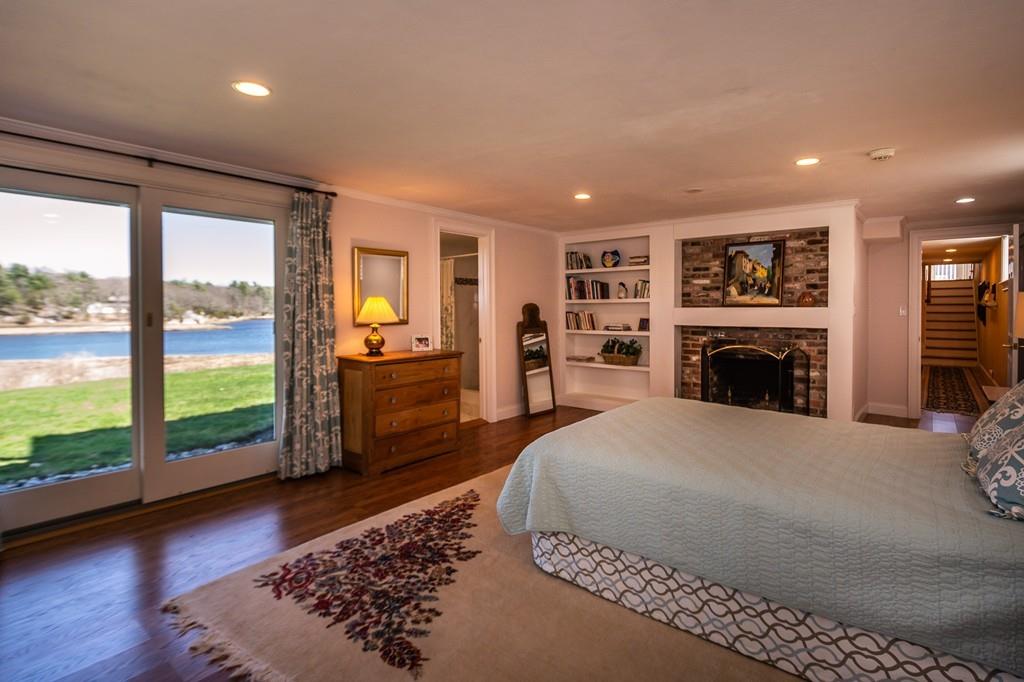 33 Stanton Road Cohasset, MA 02025 - Photo 31 of 40 a spacious bedroom with a large bed and a fireplace