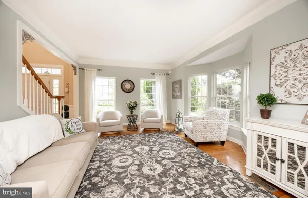 a view of a dining room and livingroom with furniture a rug a flat screen tv and a view of kitchen