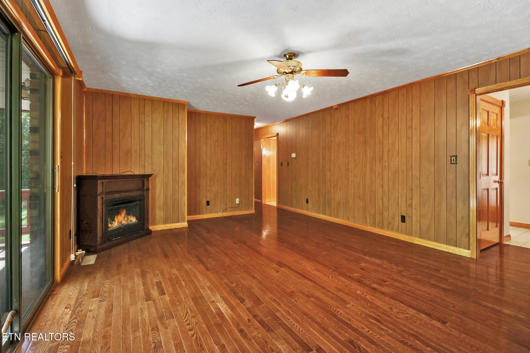 1190 Sand Cut Road Oneida, TN 37841 - Photo 12 of 41 a view of an empty room with wooden floor fireplace and a window