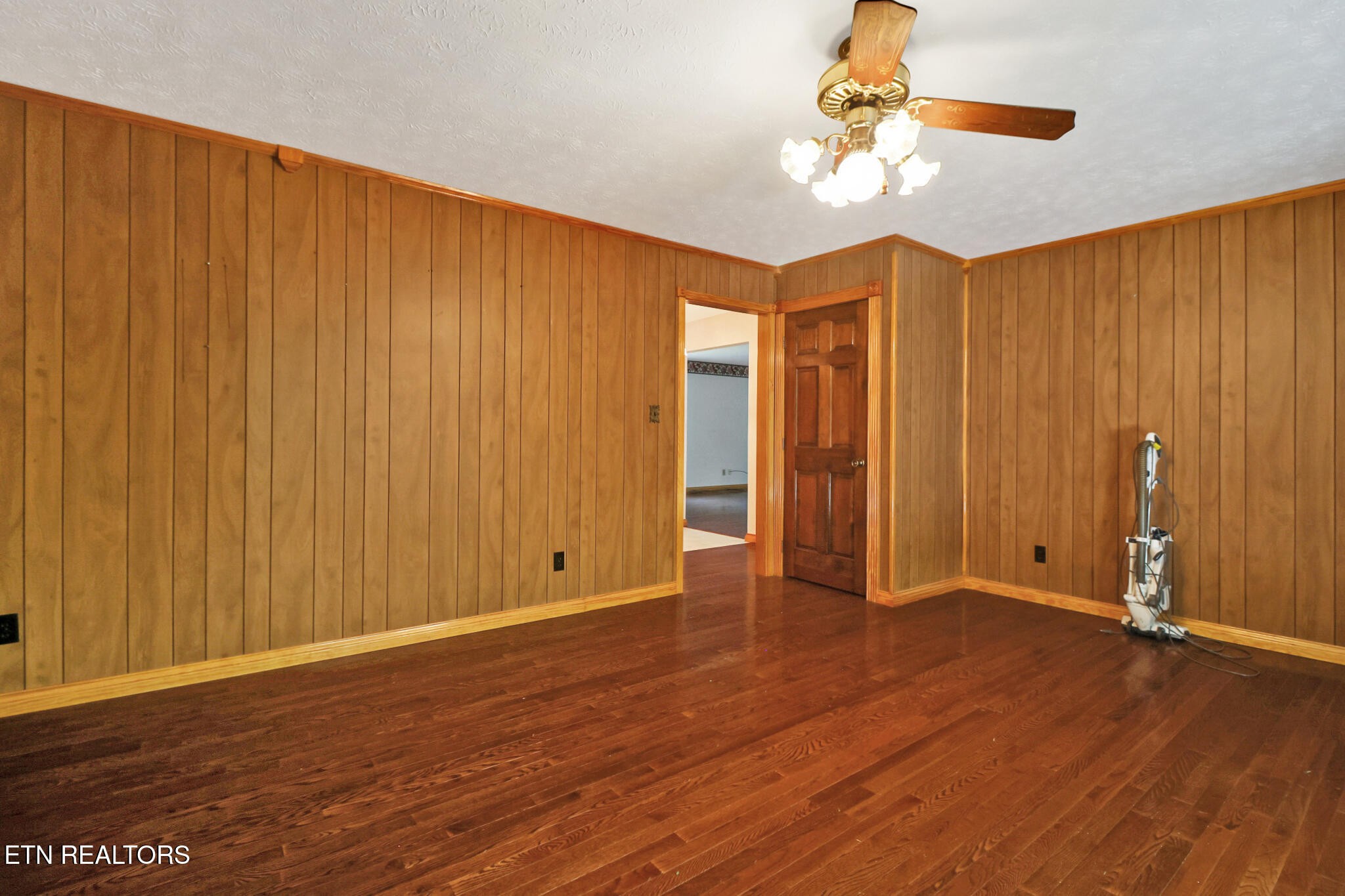 1190 Sand Cut Road Oneida, TN 37841 - Photo 15 of 41 an empty room with wooden floor chandelier fan and windows