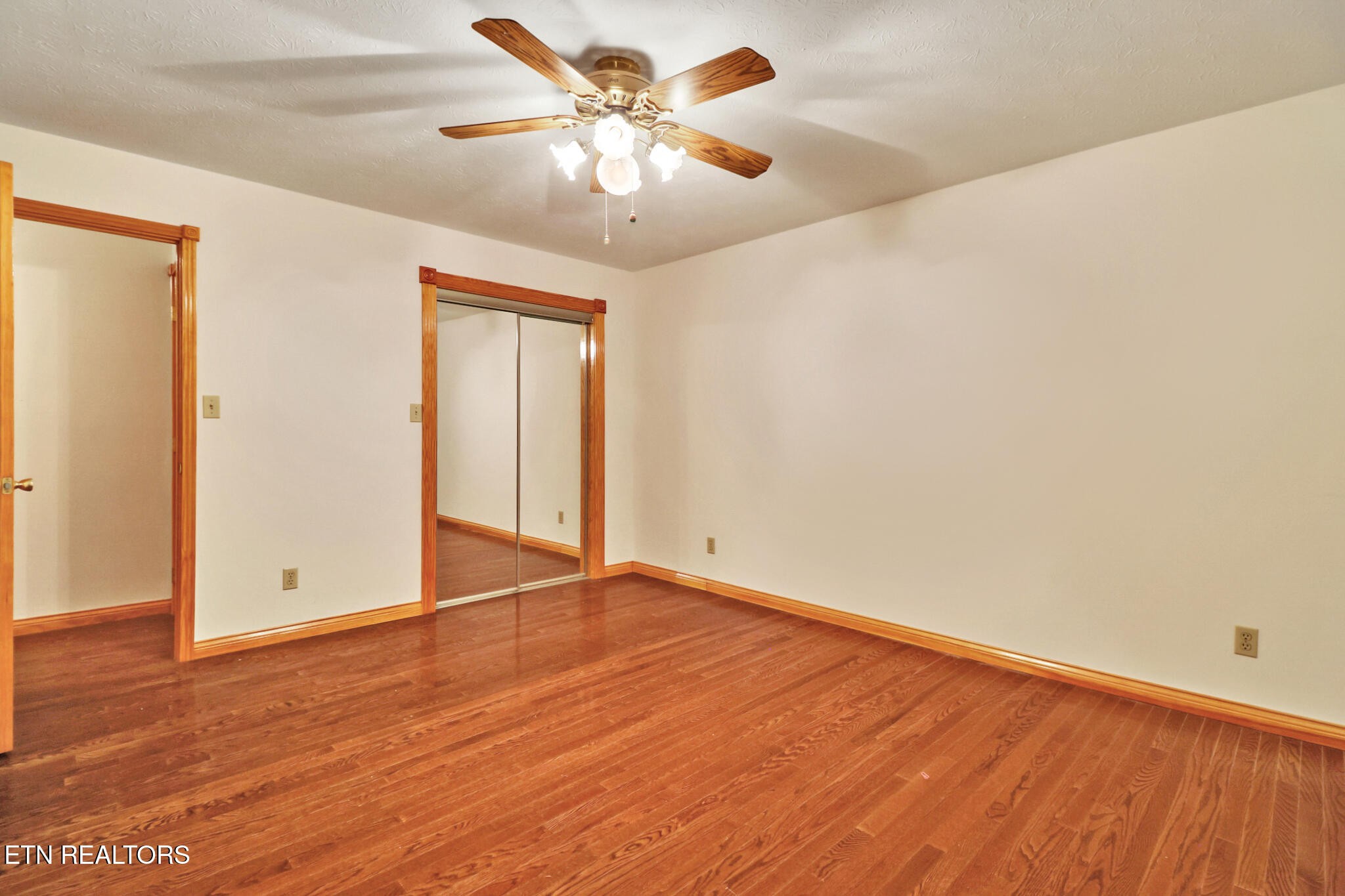 1190 Sand Cut Road Oneida, TN 37841 - Photo 19 of 41 an empty room with wooden floor and a ceiling fan