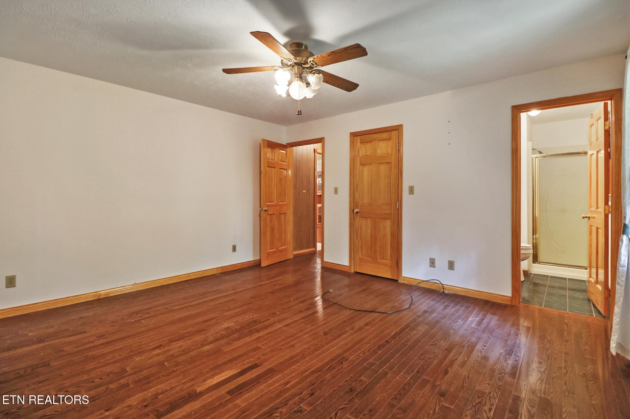 1190 Sand Cut Road Oneida, TN 37841 - Photo 21 of 41 an empty room with wooden floor and ceiling fan