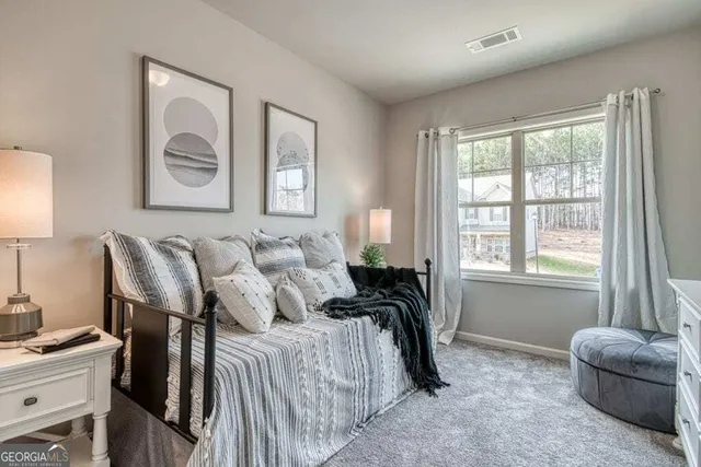 a bedroom with a bed couches chair and a window