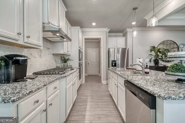 a large kitchen with granite countertop lots of counter space and stainless steel appliances