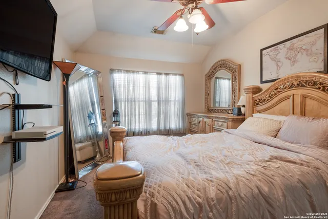 a bedroom with a bed and a mirror on the dresser