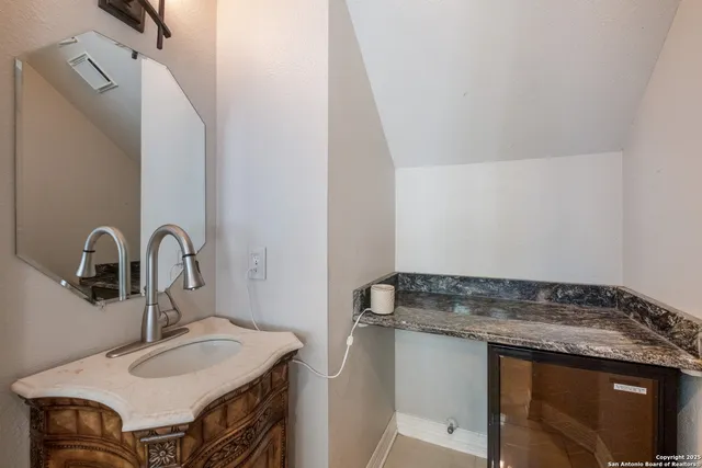 a bathroom with a granite countertop sink and a mirror
