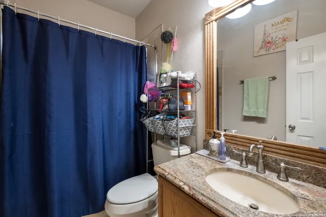 a bathroom with a granite countertop sink toilet and shower