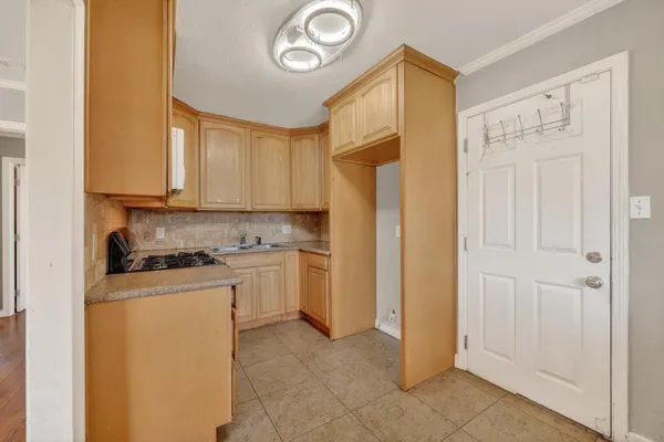 a kitchen with a refrigerator a stove top oven and cabinets
