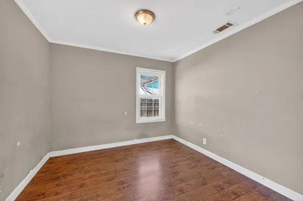 an empty room with wooden floor and closet